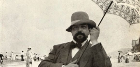 Photo of Debussy on the beach holding an umbrella